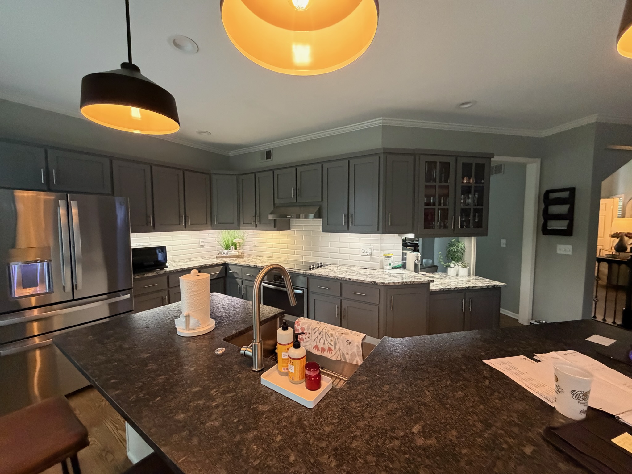 Kitchen with the original darker cabinetry before refinishing, seen across the island toward the range wall
