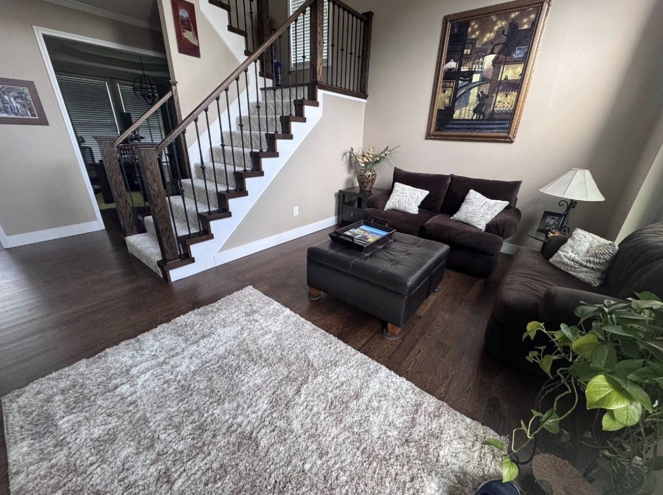 Completed living room with new wood flooring and the finished staircase with wood end caps and railings