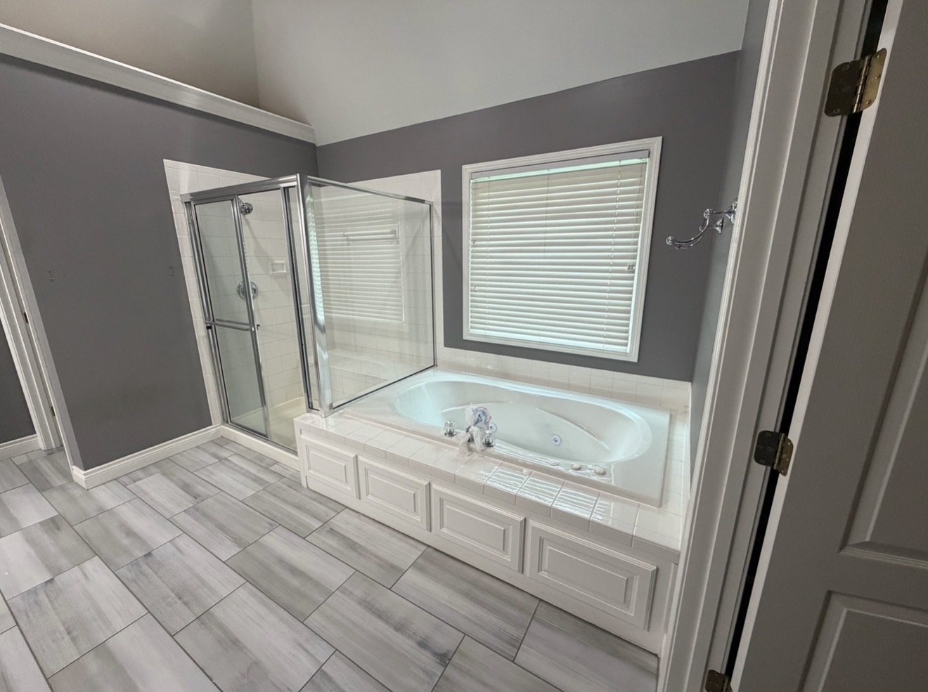 Primary bathroom before the remodel with built-in jetted tub and enclosed corner shower