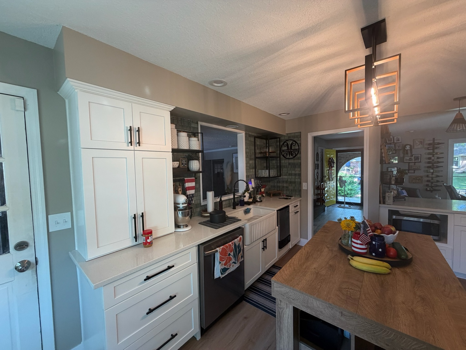 Completed kitchen looking down the island toward the squared-off opening and adjoining rooms