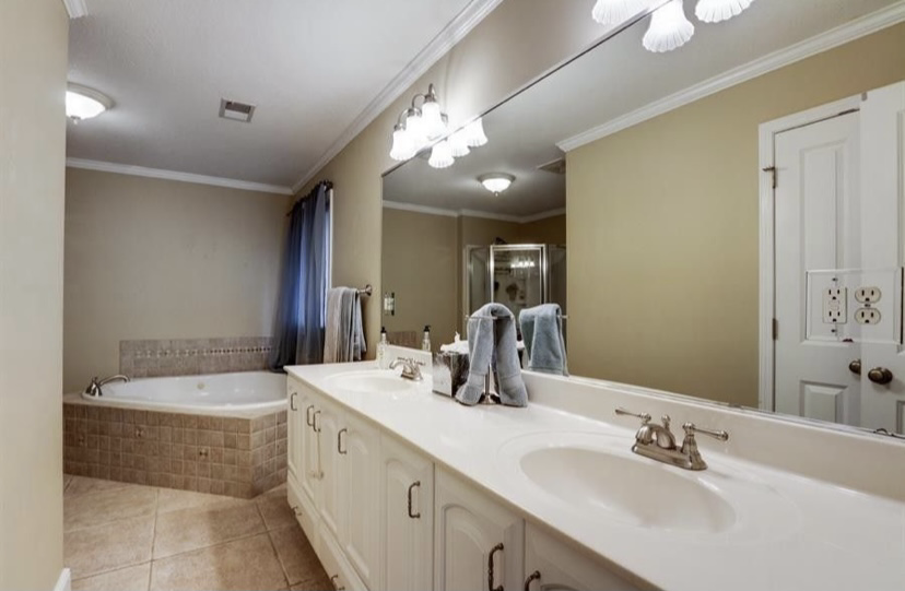 The original bathroom from a second angle, showing the corner jetted tub and the enclosed shower