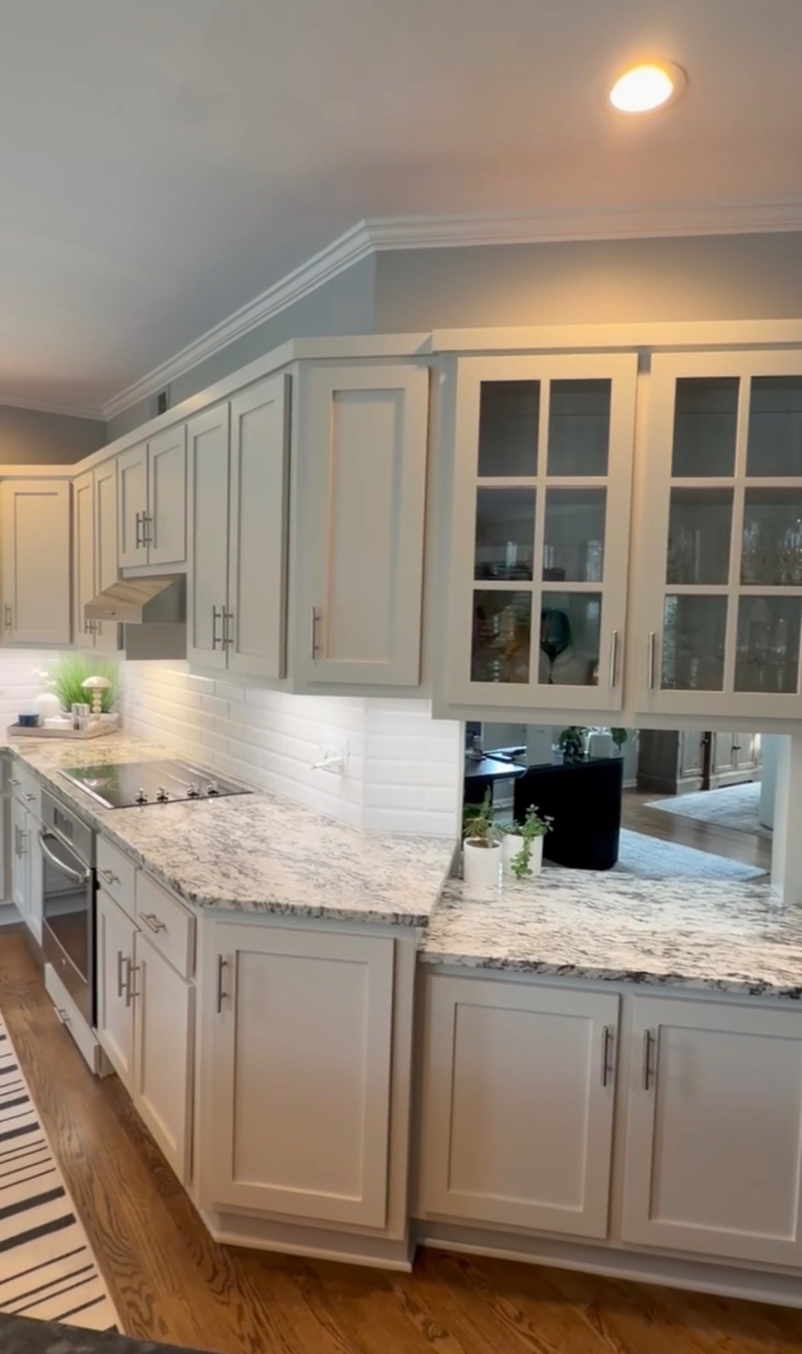 Refinished light cabinetry along the range wall and glass-front uppers after the work was completed