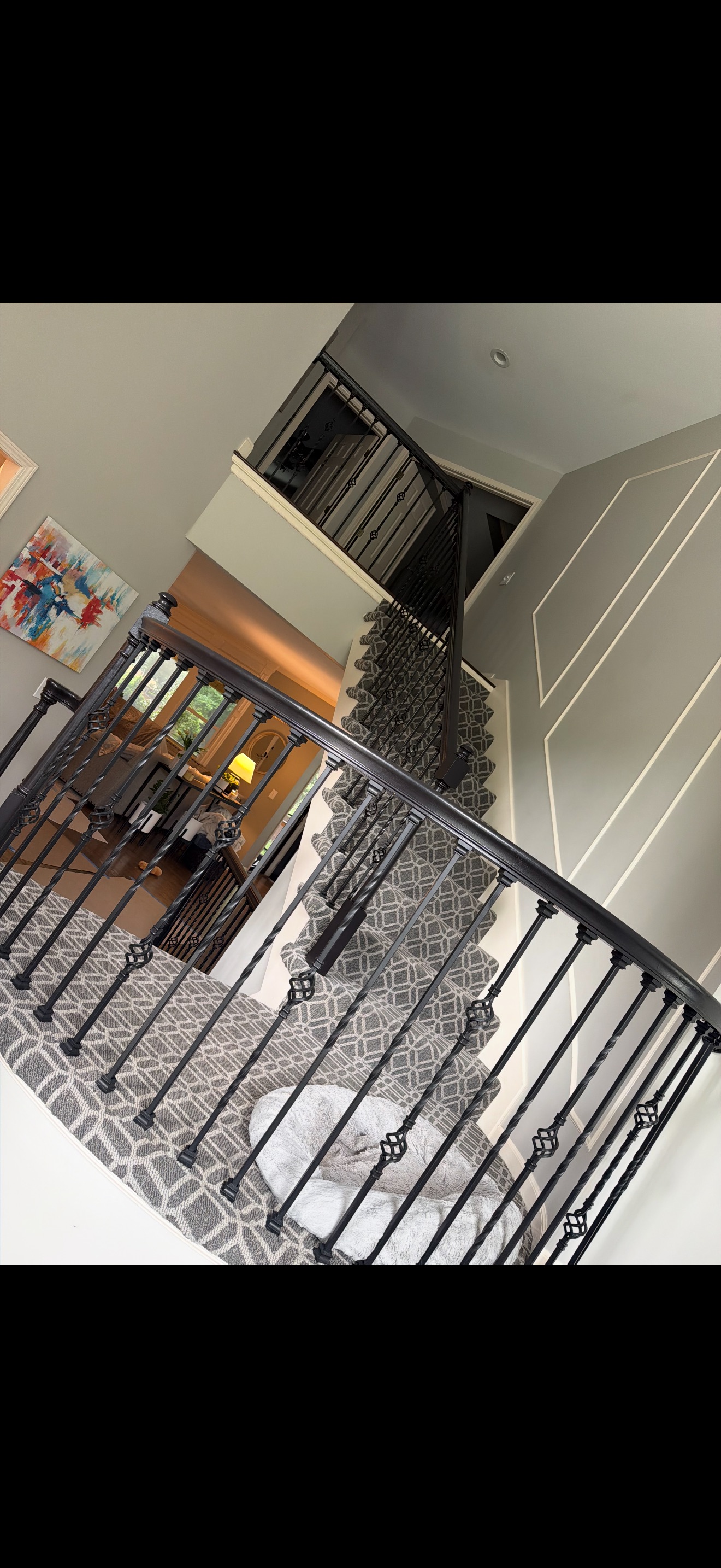Original staircase railing and balusters before the work, looking down the carpeted stairs