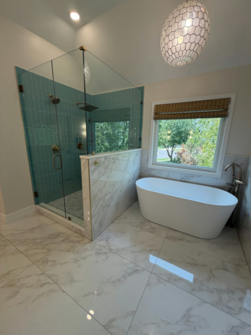 Completed glass shower and freestanding tub seen from the bathroom entry