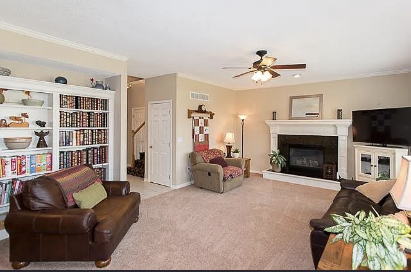 Original living room closed off by full-height walls, with carpet, built-in bookcases and a fireplace